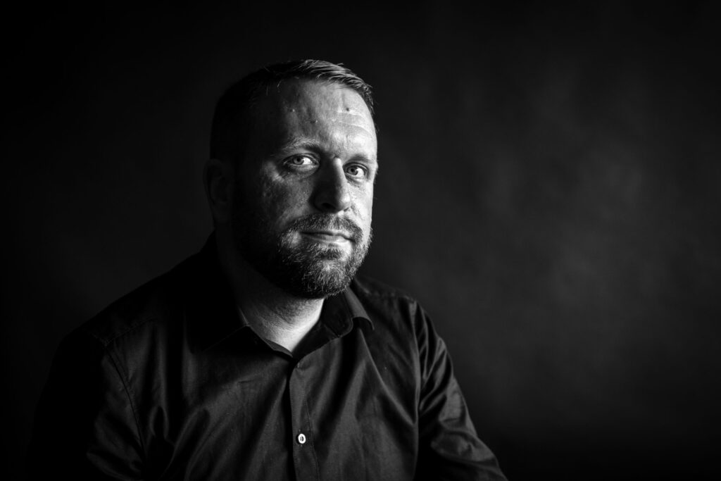 Schwarz weiß Portrait von Michael Koopmann. Person in schwarzen Hemd